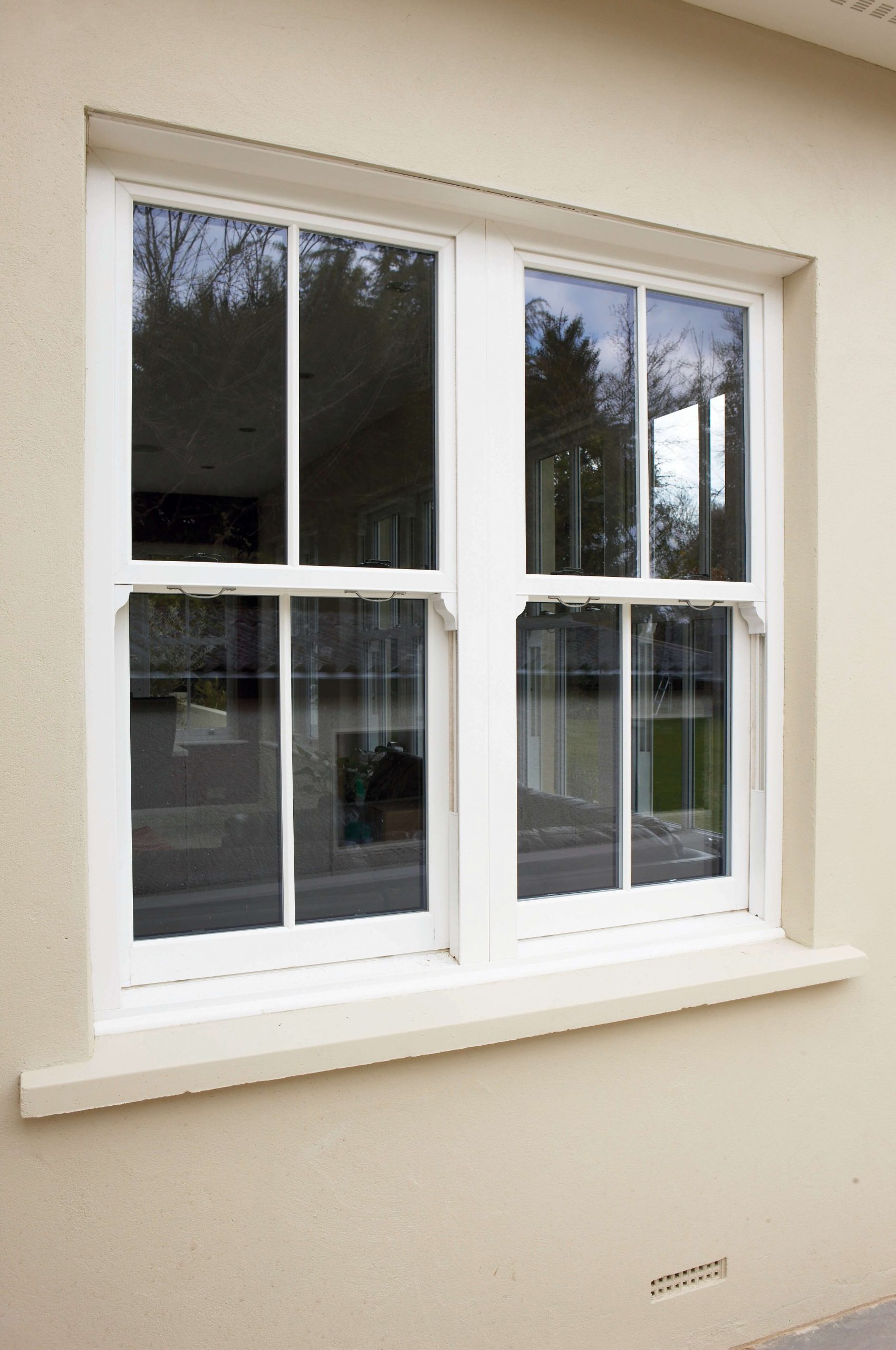 simple white sliding sash window on cream building in Basildon